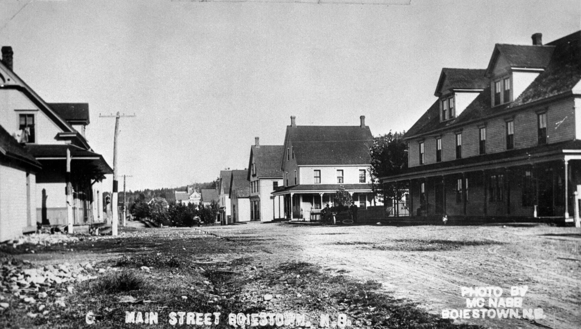 Duffy’s Hotel is the first building on the right. We know that photo was taken after 1902, because the awning was only added then. The home next door is the Campbell house, ran by two sisters and operated Boiestown’s post office. The first building on the left is the train station. (Provincial Archives of New Brunswick P54\15)