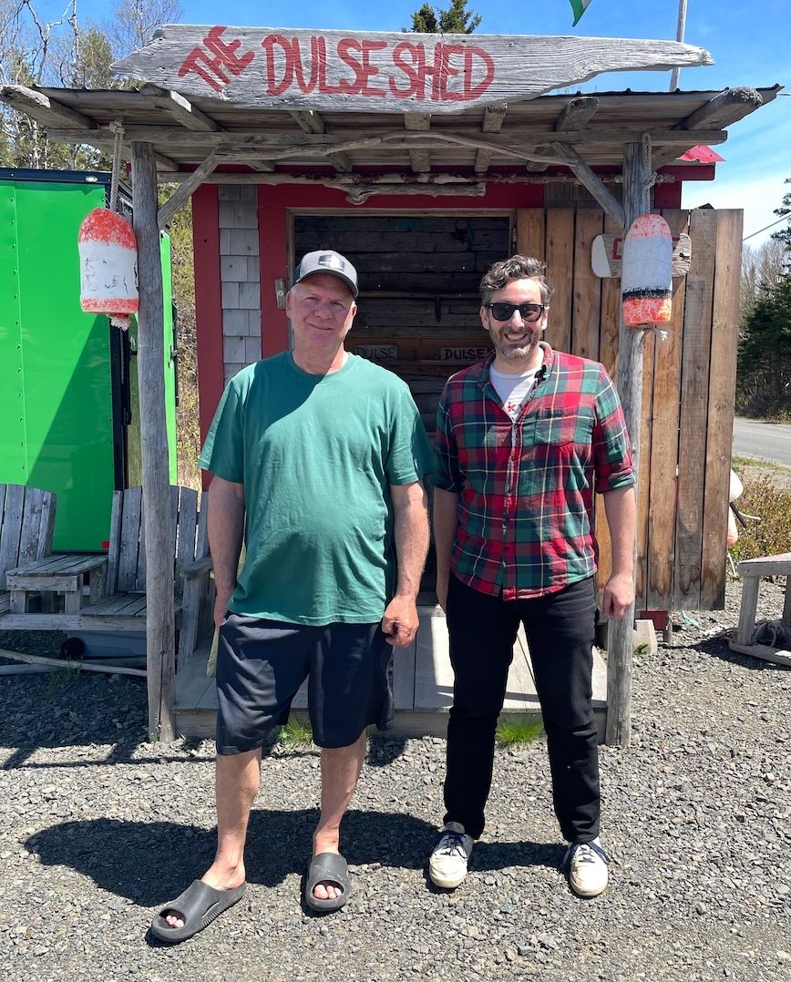 The author (right) and Wayne Greene (left) in front of Green Sea Harvest on the road to Dark Harbour Grand Manan. “It’s a replica of the old fashioned places they used to sleep in while it dried in Dark Harbour,” Greene explained. (Crystal Richard)